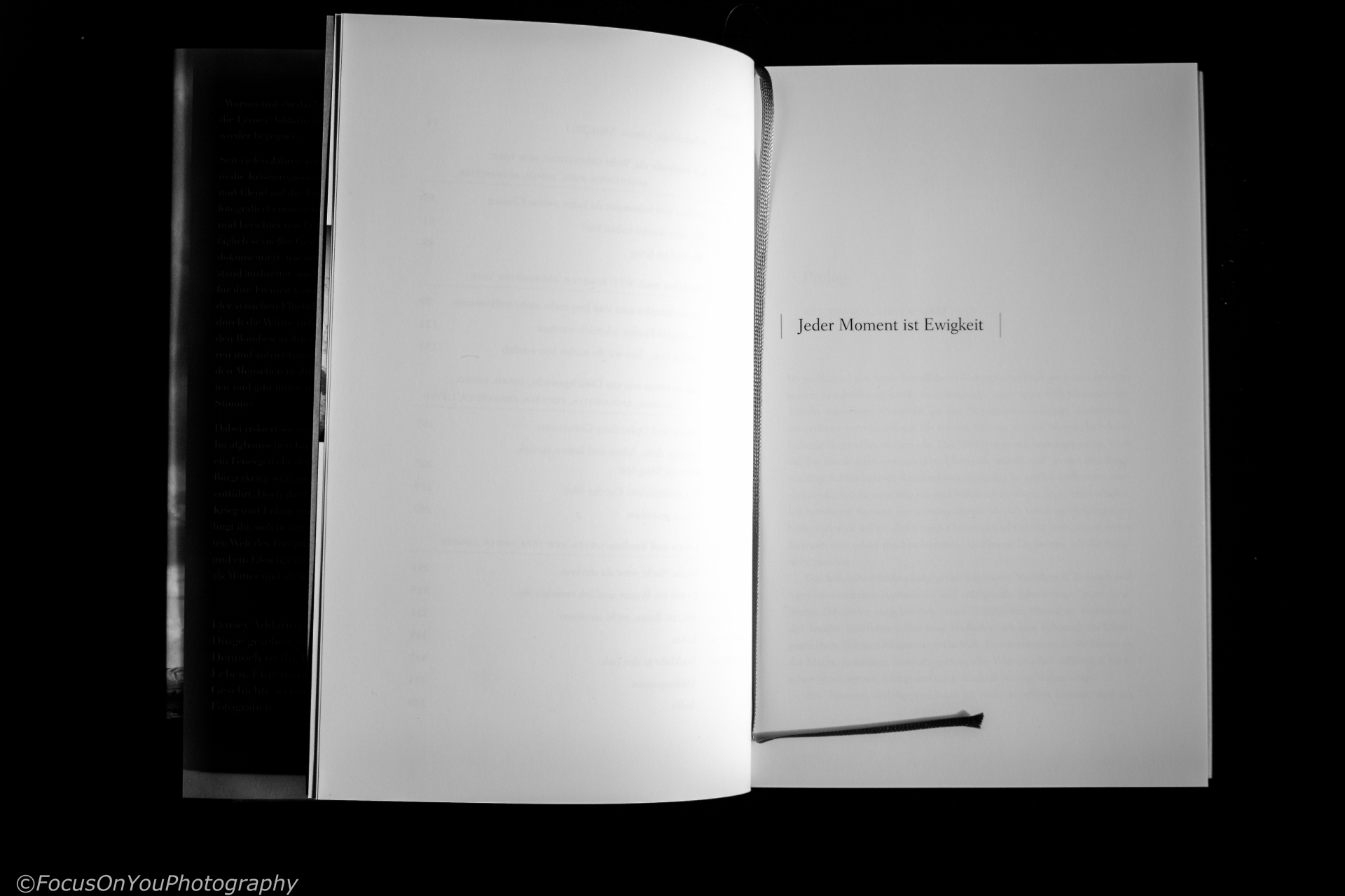ein aufgeklapptes Buch mit Lesezeichen...auf der einen Buchseite steht: Jeder Moment ist Ewigkeit ( das ist auch der Buchtitel) 